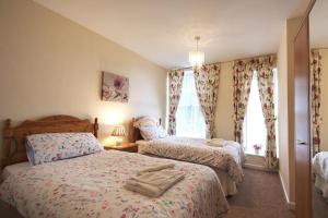 una camera da letto con due letti e una finestra di Upcott Cottage a Barnstaple Altre 6 foto