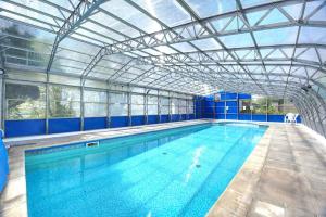 una grande piscina coperta con soffitto in vetro di Upcott Cottage a Barnstaple