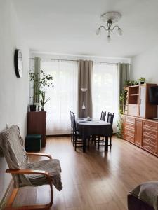 a living room with a dining room table and chairs at Silent Haven by Grafit in Legnica