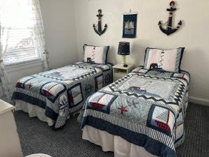 a bedroom with two beds and a lamp and a window at Two-Bedroom Wildwood Crest Condo in Wildwood Crest