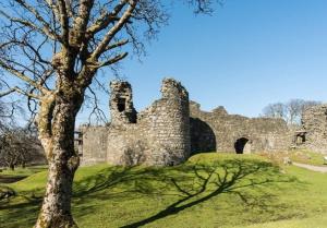 an old castle sitting on top of a green field at Little Abrach Pod in Inverlochy