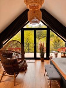 a living room with a chair and a large window at Domki Dwa jelonki - balia z jacuzzi i sauna in Wisła
