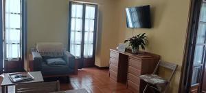 a living room with a chair and a tv at Duplex Luarca in Luarca