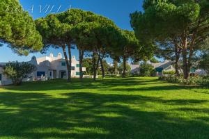 un ampio cortile alberato di fronte a una casa di Penthouse L&A Prainha with sea view, 2 Terraces ad Alvor