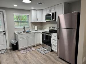 a kitchen with white cabinets and a stainless steel refrigerator at Mae's Place in Savannah