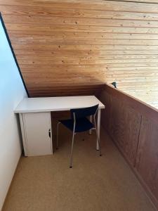 a desk and a chair in a room with wooden walls at FeWo Denkerstraße in Rendsburg