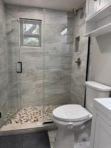 a bathroom with a toilet and a glass shower at Mae's Place in Savannah +10 photos