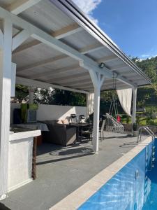 a white pergola over a swimming pool at Villa Dzeno Sarajevo in Krivoglavci