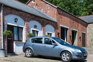 a small blue car parked in front of a brick building at Carriage House in Barnstaple