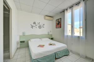 a bedroom with a bed in a room with a window at Hotel Camille in Saintes-Maries-de-la-Mer