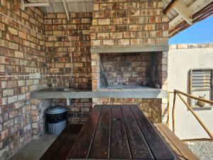 a brick oven with a wooden bench in a brick wall at Carlo's Mountain Lodge in Usakos
