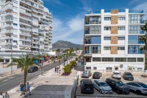 eine Stadtstraße mit Autos vor hohen Gebäuden in der Unterkunft ALAY NEARBY BEaCH in Benalmádena
