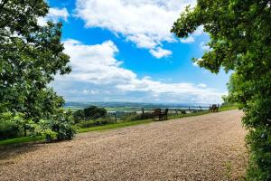 un camino de grava con árboles y un cielo azul en Tracy, en Barnstaple