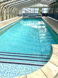 Una gran piscina con agua azul en un edificio. en Tracy, en Barnstaple