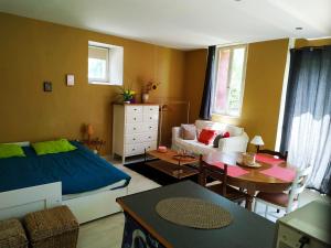 a living room with a bed and a table at Studio tout confort proche de Joigny in Chamvres