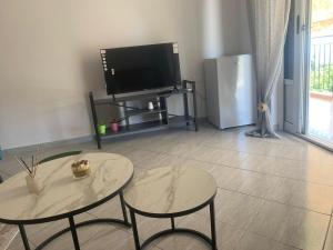 科帕罗Qeparo View Rooms的客厅配有2张桌子和平面电视