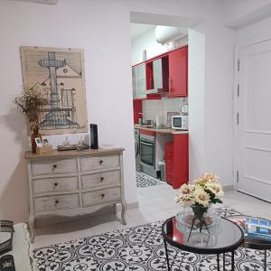 a kitchen with red cabinets and a table with flowers at Escapada junto a Picasso in Málaga