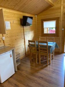 a dining room with a table and a television in a cabin at 7 Seas in Wrzosowo +12 photos