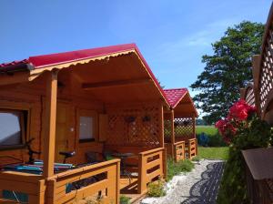a small wooden cabin with a red roof at 7 Seas in Wrzosowo