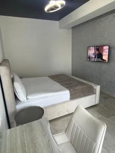een slaapkamer met een bed en een tv aan de muur bij SIGMA suites in Constanţa
