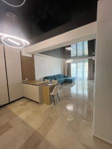 een woonkamer met een blauwe bank en een tafel bij SIGMA suites in Constanţa