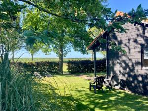 twee stoelen in het gras naast een huis bij Landelijk gelegen houten huisje in Opperdoes +20 foto's