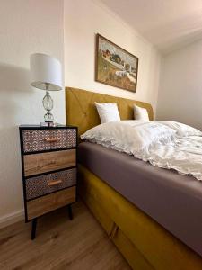 ブレーメンにあるSchön gelegene und gemütliche Ferienwohnung am Weseruferのベッドルーム1室(ベッド1台、ドレッサー、ランプ付)