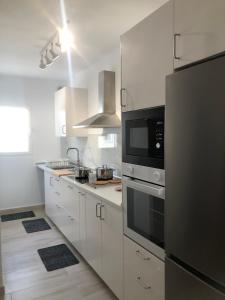a kitchen with white cabinets and a stainless steel refrigerator at Casa Yolanda in Tías
