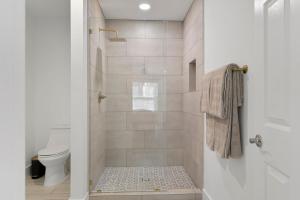 a white bathroom with a shower with a toilet at Lake Hartwell Escape!- Cabin for groups & families in Westminster +13 photos