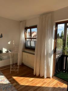 a living room with a window with a table and a balcony at Cozy City Apartment Penzberg in Penzberg