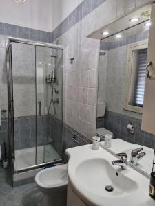 un bagno con doccia, lavandino e WC di Happie Casa Stazione Centrale a Palermo