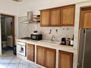una cucina con lavello e microonde di Happie Casa Stazione Centrale a Palermo Altre 3 foto