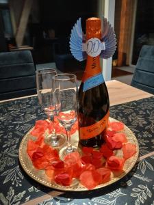 a bottle of wine and two glasses on a table at Domek nad Jeziorkiem Sauna -Silownia-Balia in Waliska +10 photos