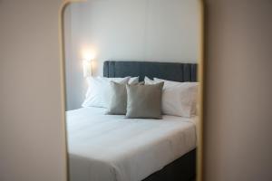 a mirror reflection of a bed with white pillows at Aurora Apart, 4 - Sea view suites near the beach in Marmari