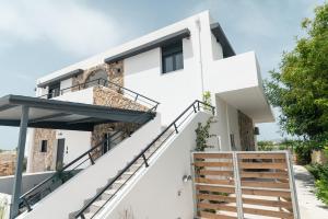 a white house with stairs in front of it at Aurora Apart, 4 - Sea view suites near the beach in Marmari