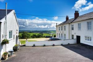 ein Auto, das vor einem weißen Haus parkt in der Unterkunft Courtney in Barnstaple