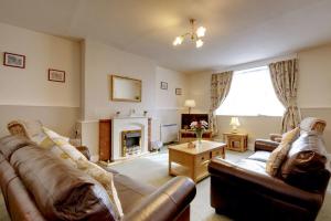 ein Wohnzimmer mit zwei Sofas und einem Kamin in der Unterkunft Courtney in Barnstaple + 1 Foto