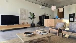 a living room with a tv and a coffee table at Villa São Roque in Ponta Delgada