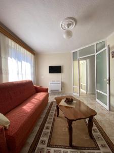 a living room with a red couch and a coffee table at Central Stay Pogradec in Pogradec