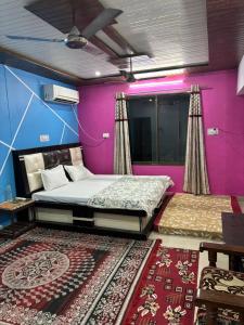a bedroom with two beds and a purple wall at Sarita's homestay in Ayodhya