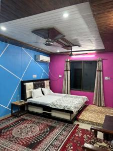 a bedroom with a bed and a purple wall at Sarita's homestay in Ayodhya
