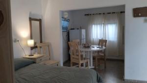 a room with a bed and a table and a refrigerator at Las Vasijas in Villa Amancay