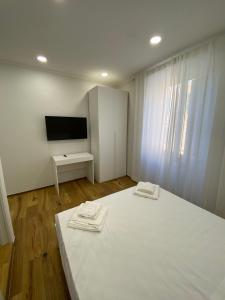 a white room with a bed and a tv at Begonia Apartment in Rome