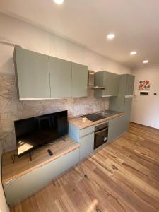 a kitchen with white cabinets and a television in it at Begonia Apartment in Rome