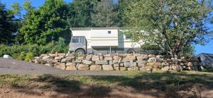 a camper truck parked next to a pile of rocks at Terre divine in Saint-Maurice-lès-Couches