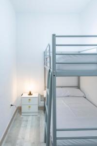 a bedroom with two bunk beds and a night stand at Bungalow Golf del Sur in San Miguel de Abona +32 photos
