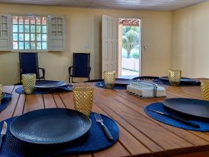 a conference room with a large wooden table with blue plates at Casa Mar Azul - Pé na areia de Praia azul in Pitimbu