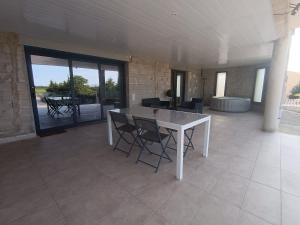 a white table and chairs in a room with a patio at Appartement moderne in Pia