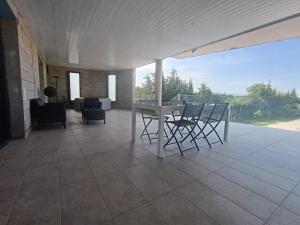 a patio with a table and chairs on a tile floor at Appartement moderne in Pia