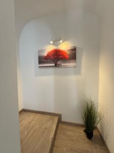 a painting of a red tree on a wall at Tuscany Hills - Comfort 10 minutes from Montepulciano and Pienza in Torrita di Siena
